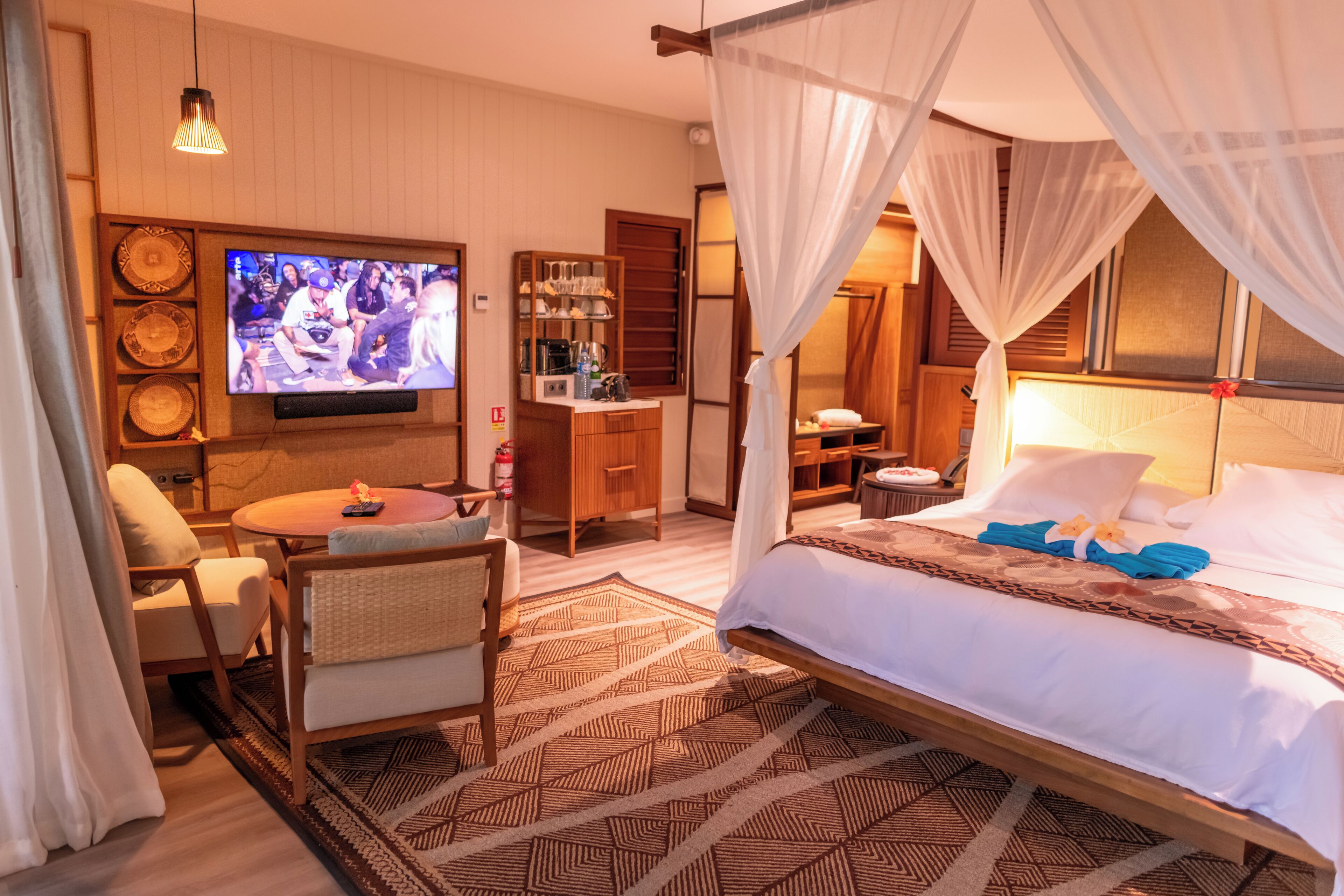 A hotel room with a bed, a TV, a desk, and a chair.