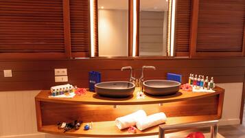 A bathroom with a wooden vanity, two sinks, and a mirror above.