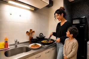 A kitchen with a sink, stove, and a microwave. - One Stay Shinsaibashi (Osaka)