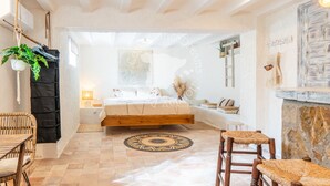 A spacious bedroom with a large bed, a wooden floor, a round patterned rug, and a view of the outside. - CostaBlancaDreams - Casa Hella in Calpe (Calpe)