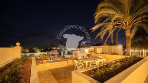An outdoor patio area with a dining table and chairs, surrounded by plants and a palm tree. - CostaBlancaDreams - Casa Hella in Calpe (Calpe)