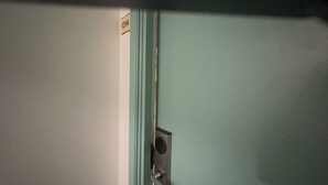 Una porta con una targa recante il numero 1314 e una maniglia metallica.