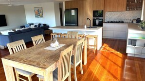 Una cocina moderna con una isla central, una mesa de comedor de madera y sillas.