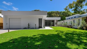 A modern two-story house with a flat roof, a garage, and a well-maintained lawn. - Navy'S By The Beach - Rainbow Shores (Rainbow Beach)