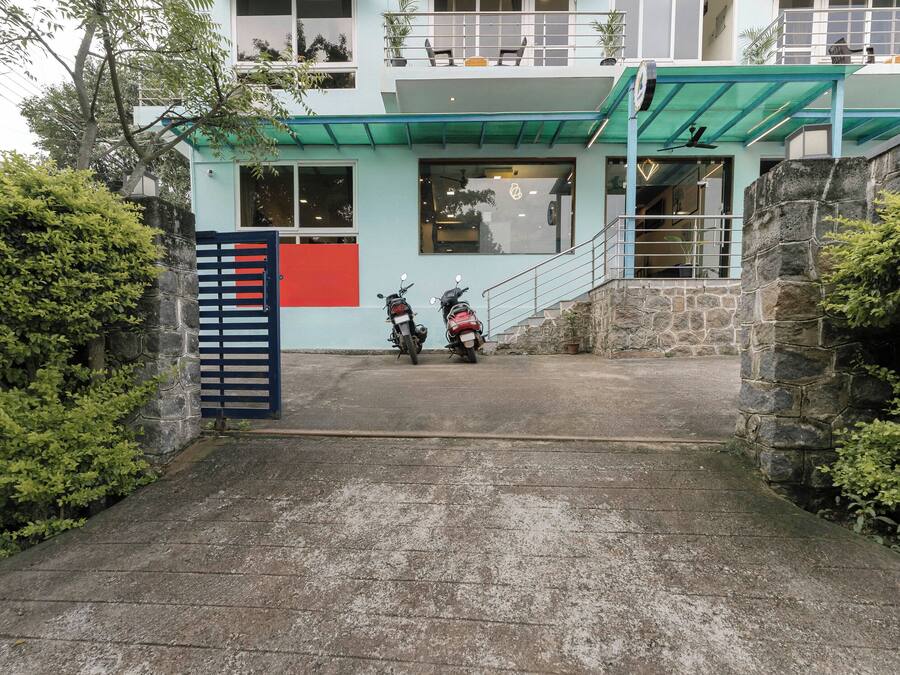 Entrada de prédio com duas motocicletas estacionadas na frente.