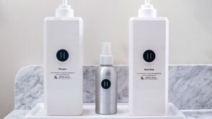Two white bottles of Moss Hill body wash and shampoo on a marble countertop. - Hollyhock Suite 504: 1 bed/1 bath (Louisville)