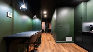 Una cocina moderna con paredes verdes, encimera de madera y estufa integrada.