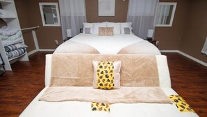 Un dormitorio amplio con una cama grande, un sofá cama y un armario.