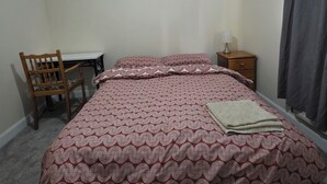 A bedroom with a bed, a desk, a chair, a nightstand, and a lamp. - Stay Near Colchester twn centre4 (Colchester)