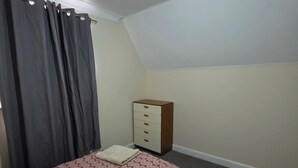 A bedroom with a bed, a dresser, and a ceiling light. - Stay Near Colchester twn centre4 (Colchester)