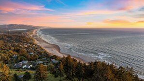 Une ville côtière dotée d’une plage, de maisons et d’une zone boisée.