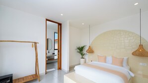 Een moderne slaapkamer met een groot bed, een houten plank, een potplant en een accentmuur van steen.