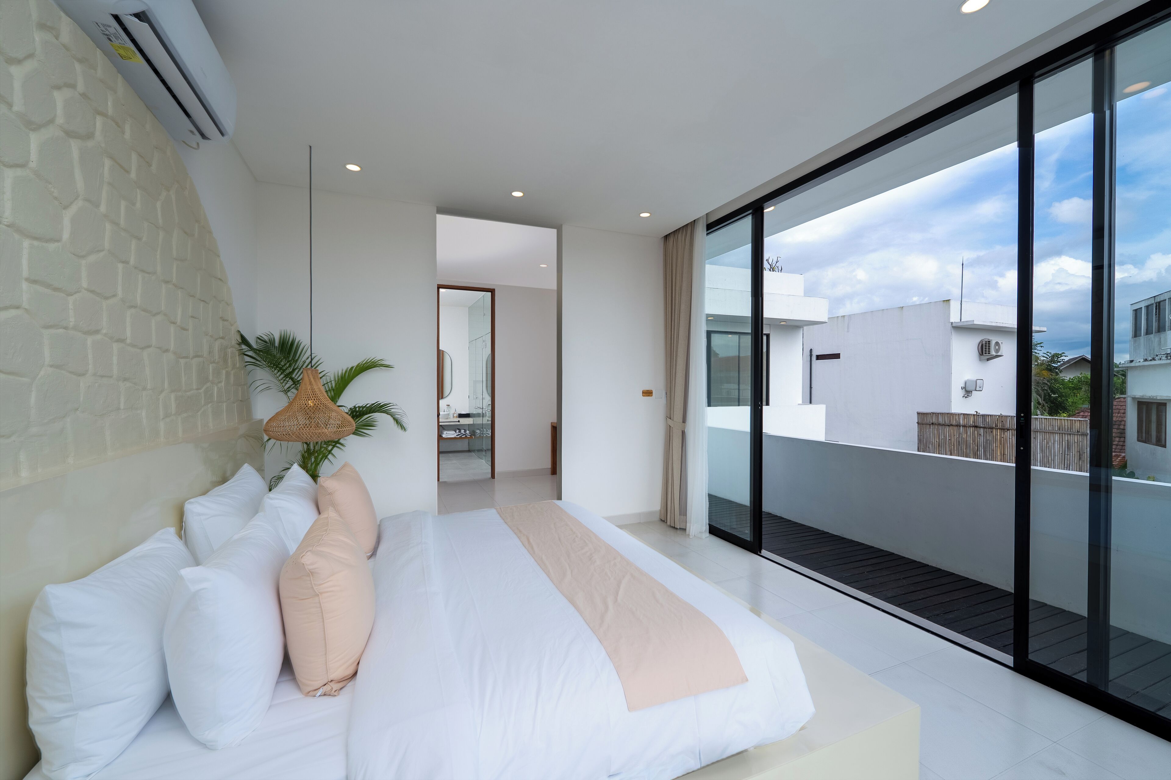 Ein modernes Schlafzimmer mit einem großen Bett, Blick auf die Stadt und einem Balkon.
