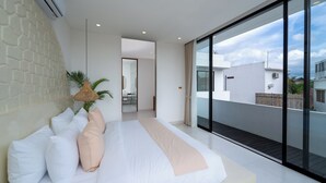 Een moderne slaapkamer met een groot bed, uitzicht op de stad en een balkon.