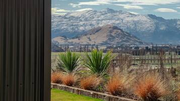 A hot tub with a view of a mountainous landscape and a city in the distance.