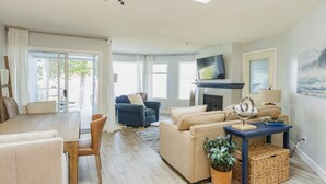 Un salon moderne avec un canapé, un téléviseur et une cheminée.
