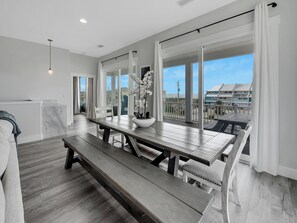 Une cuisine moderne avec une grande table à manger, un banc et une vue sur la plage.