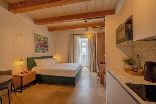 Un dormitorio con cama, mesita de noche, lámpara y un cuadro en la pared.