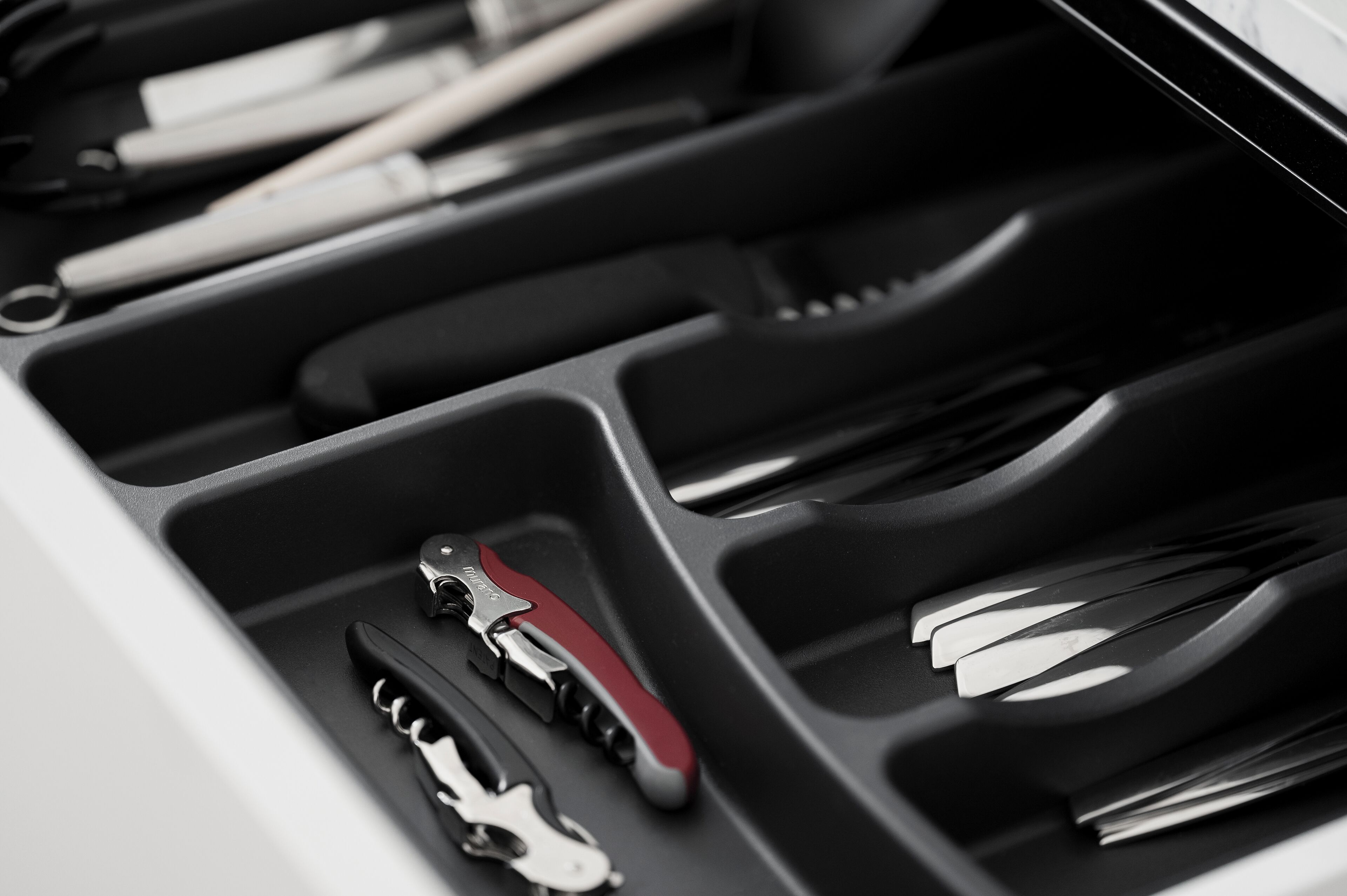 A car's center console with various tools organized in compartments.