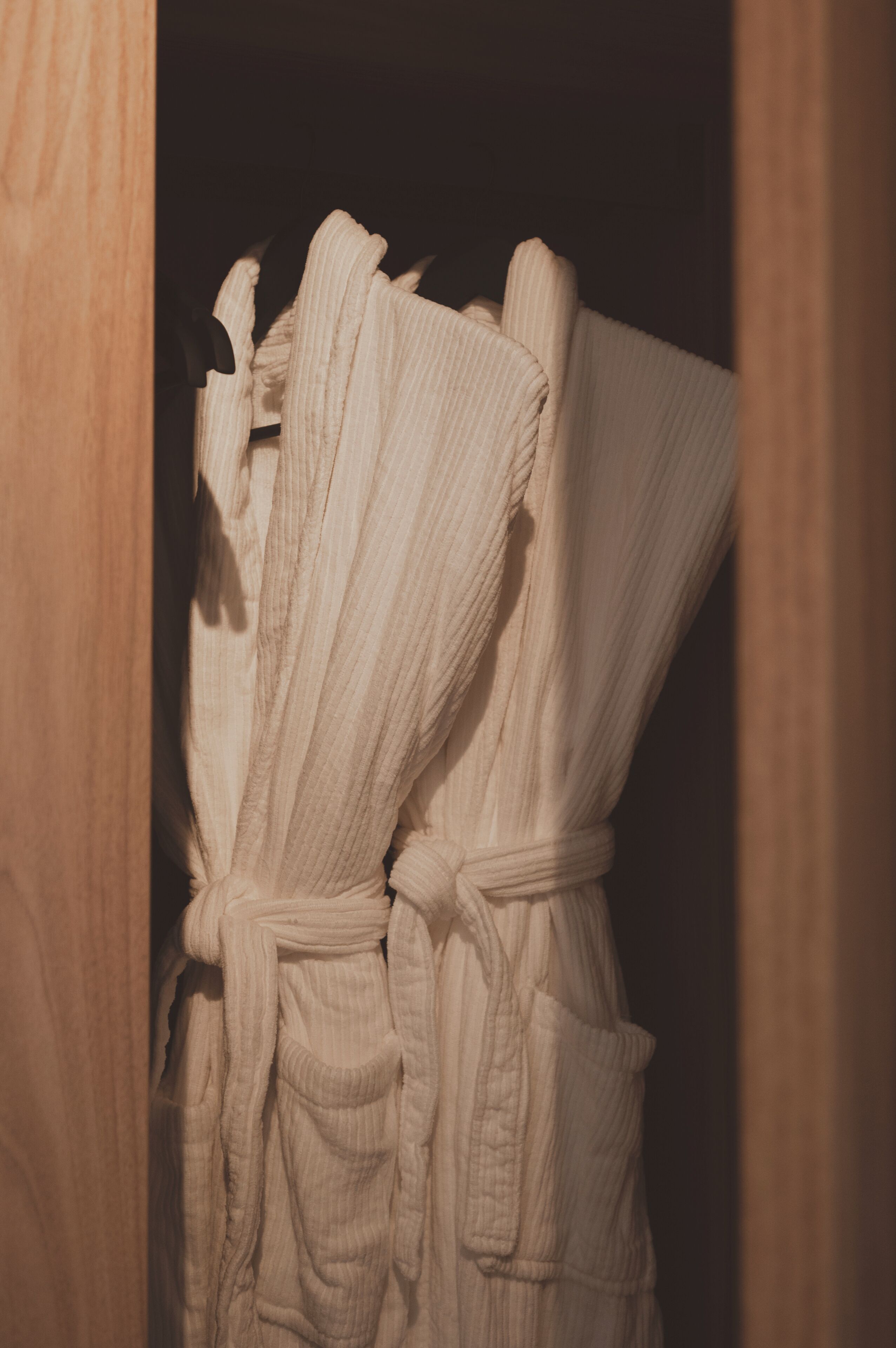Una puerta de madera con un albornoz blanco colgado en su interior.