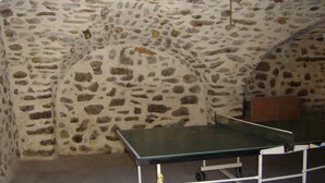 A stone-walled room with a ping pong table. - Gite la petite cascade - Haut Verdon Val d'Allos (Allos)