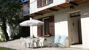 A patio with a table, chairs, and an umbrella. - Gite la petite cascade - Haut Verdon Val d'Allos (Allos)