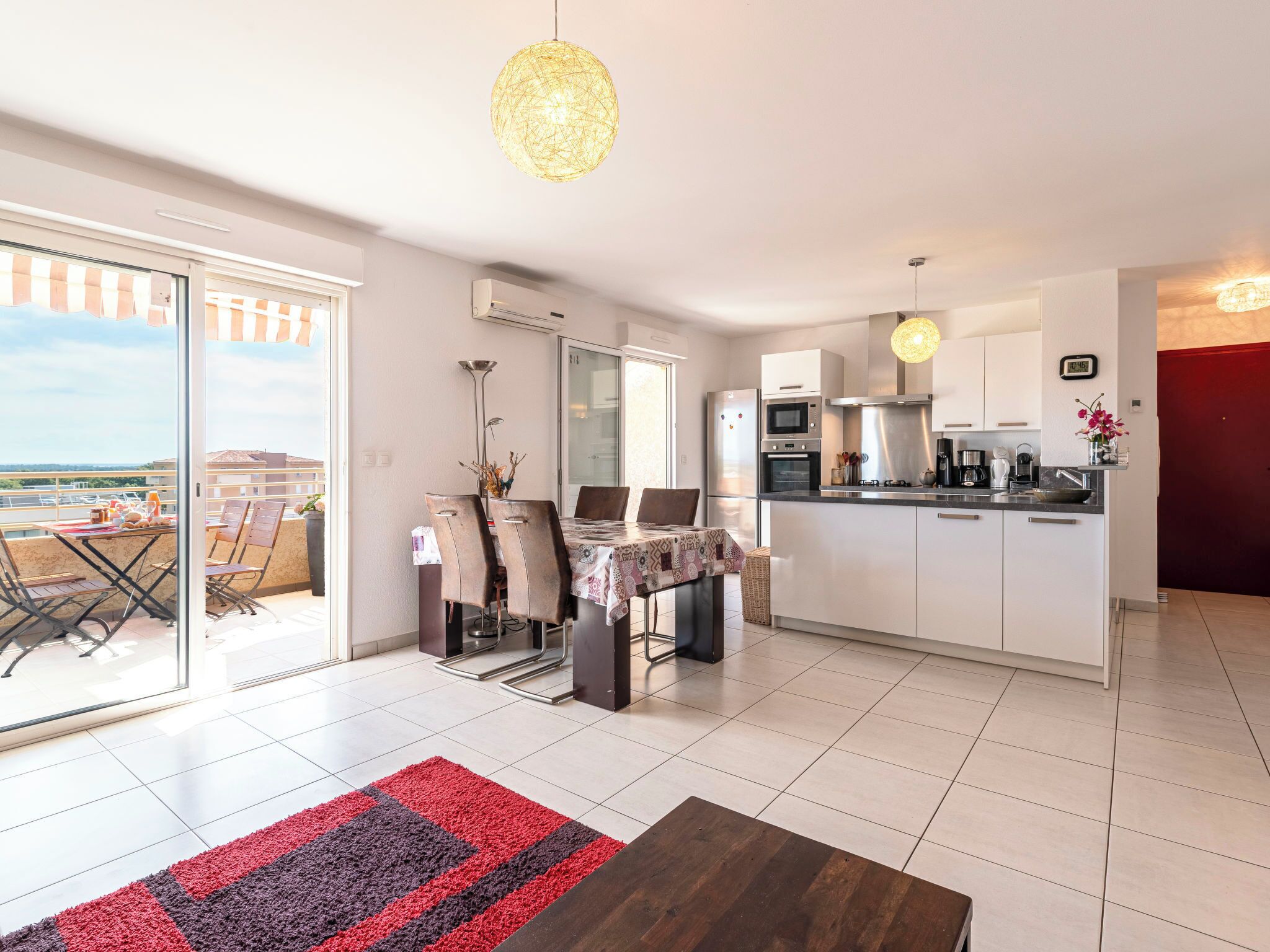 Eine moderne Wohnung mit Essbereich, Küche und einem Balkon mit Blick.