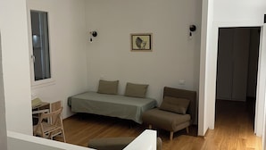 Een kamer met een bed, een slaapbank, een bureau en een stoel.