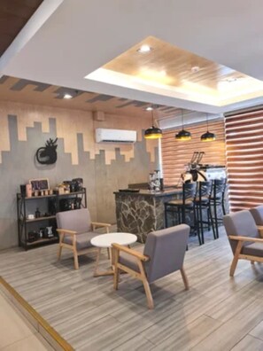 A modern interior with a bar area, seating, and a decorative wall.