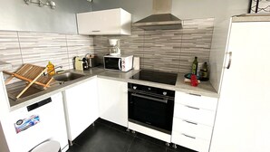 A modern kitchen with a built-in oven, microwave, and coffee maker. - "L'Océane" Studio sea view-climate-wifi-parking (La Ciotat)