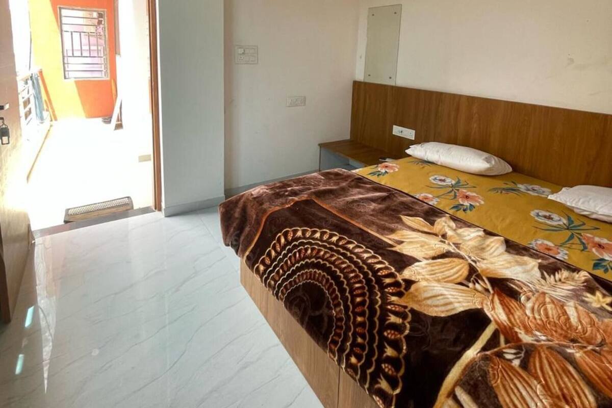 A bedroom with a bed, a ceiling fan, and a door leading to another room.