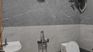 A bathroom with a toilet, sink, and shower. - Dev Residency NCR Wale (Danta Ramgarh)