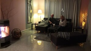 A cozy living room with a fireplace, a sofa, a coffee table, and a lamp. - Interesting vacation home by the lake and forest, Uckermark, Lychen the town of 7 lakes (Lychen)