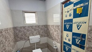 Un baño con inodoro, ducha y paredes con diseño.