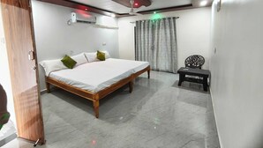 Un dormitorio con cama de madera, una mesita y un ventilador de techo.