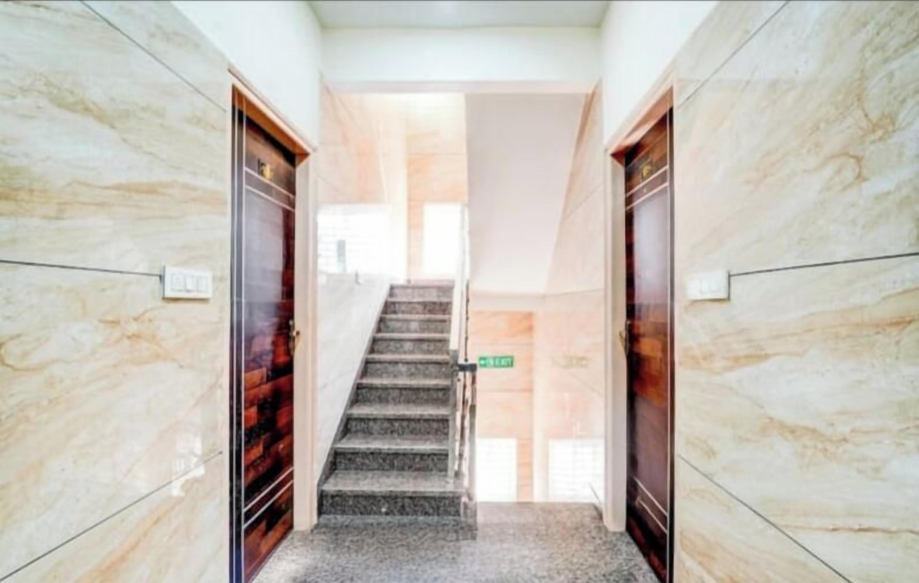 A marble-floored hallway with a staircase leading to a door labeled "Lobby".