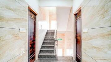 A marble-floored hallway with a staircase leading to a door labeled "Lobby".