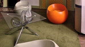 A modern living room with a glass coffee table, a white chair, and a large orange bean bag. - Room POP - Private bathroom (Montbron)