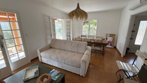 A spacious living room with a sofa, a coffee table, and a dining area with a table and chairs.