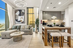 A modern living room with a sofa, coffee table, and a view of the city. - Luxury Apartments in Meydan (Dubai)