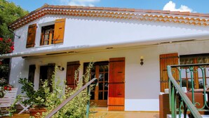 A two-story white building with a tiled roof, wooden shutters, and a covered porch with outdoor seating. - Gorgeous home in Saint Sernin (Saint Sernin)