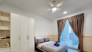 A bedroom with a bed, a wardrobe, a ceiling fan, and a window with curtains. - Twin Galaxy Residences by Widebed JB (Johor Bahru)