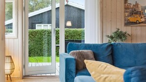 A room with a blue sofa, a door leading outside, and a framed picture on the wall.