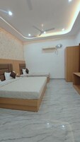 Un dormitorio con dos camas, ventilador de techo, iluminación empotrada, unidad de aire acondicionado y armario de madera.