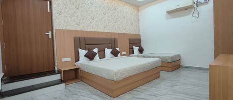A hotel room with two beds, a wooden wardrobe, a marble floor, and an air conditioning unit.