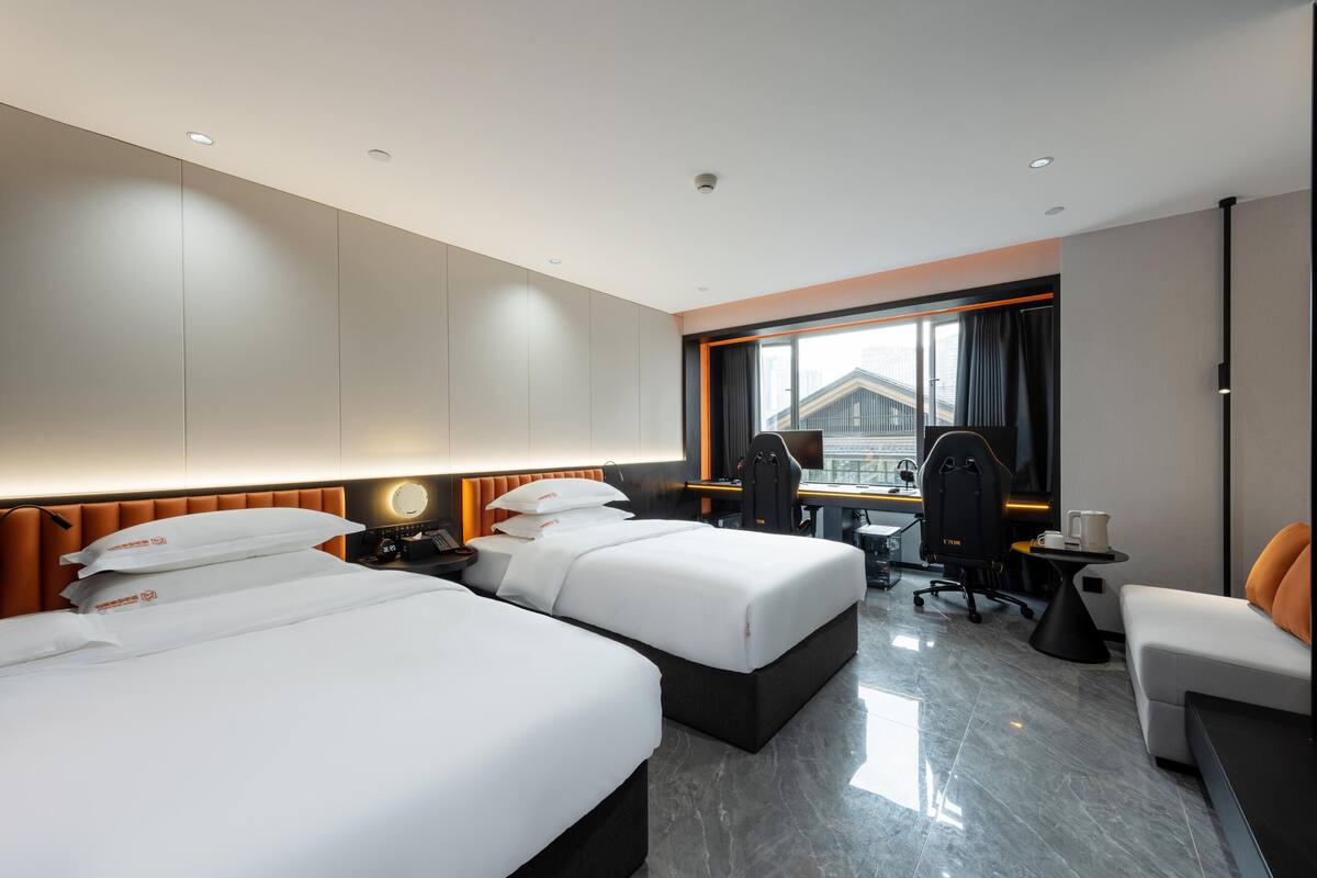 Una habitación de hotel moderna con dos camas, un escritorio y una silla.