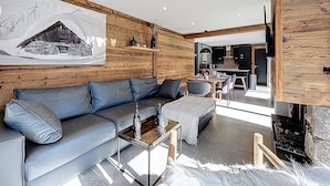 Una sala de estar moderna con un sofá gris, una mesa de centro y una chimenea.