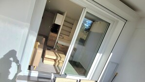 A modern room with a sliding glass door leading to a balcony with artificial grass.