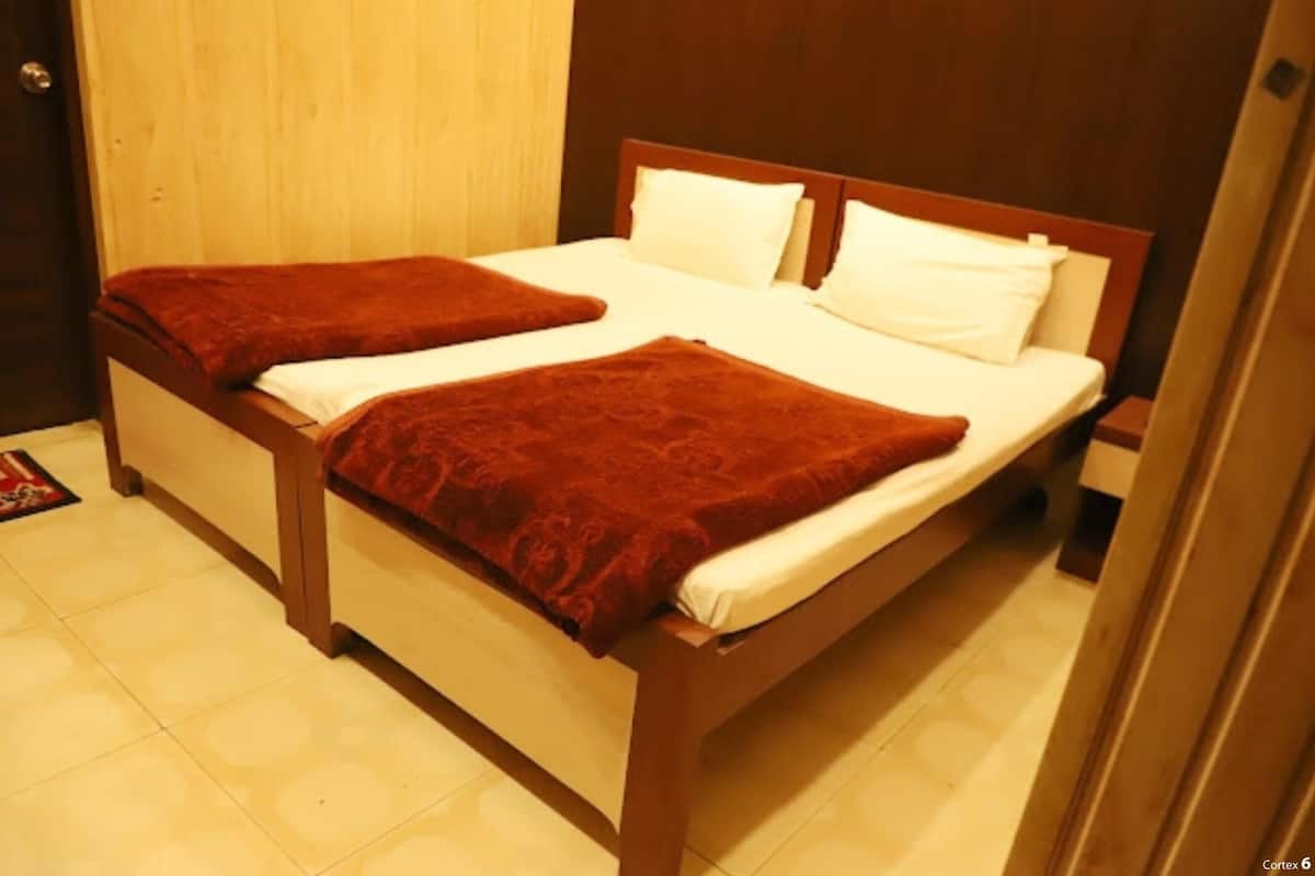 Ein Doppelbett mit Holzrahmen und zwei Kissen.