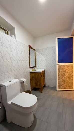 Standaard eenpersoonskamer | Badkamer | Een douche, een haardroger, pantoffels, handdoeken